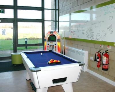 A pool table and jukebox in the social space at Castle Hill hospital