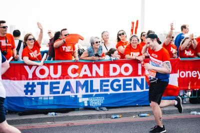 Person running london marathon past Teenage Cancer Trust  cheer squad
