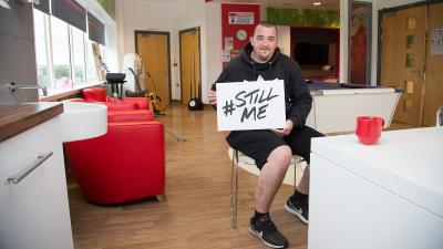 Andrew holding a sign saying #StillMe
