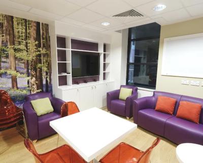 Sofas and a TV in the atrium, set in the centre of the Teenage Cancer Trust ward at Bristol Children's Hospital