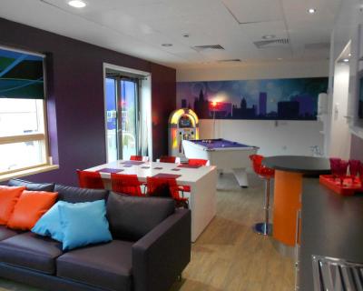 The social space at Alder Hey with a sofa, table and chairs, table football and jukebox