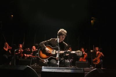 Noel Gallagher on stage at the Royal Albert Hall in 2007 with an orchestra behind him