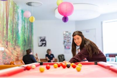 Young person playing pool on Teenage Cancer Trust unit