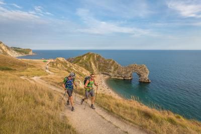 Walkers completing the Jurassic Coast challenge walking past Durdle Door