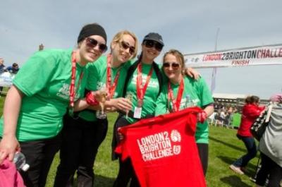 Walkers holding a London 2 Brighton Challenge t-shirt at the event finish line