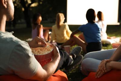 A man eats popcorn watching a movie at a film night to raise money for Teenage Cancer Trust