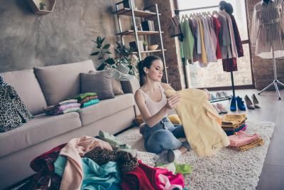A woman decluttering her old clothes to sell to raise money for Teenage Cancer Trust