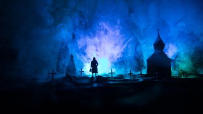 A person walking in a misty graveyard as part of a ghost walk to raise money for Teenage Cancer Trust