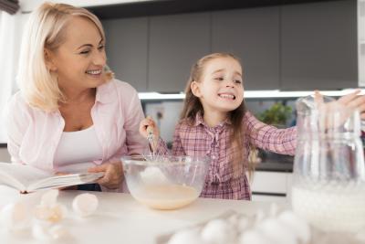 A young girl with her mum creating a recipe for a recipe book to be sold at her primary school to raise money for Teenage Cancer Trust