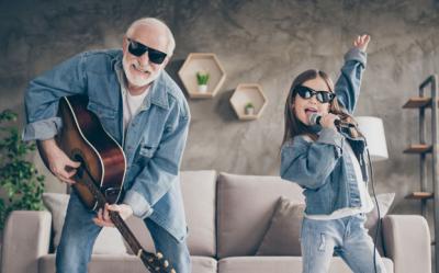 A man and his granddaughter singing and playing guitar