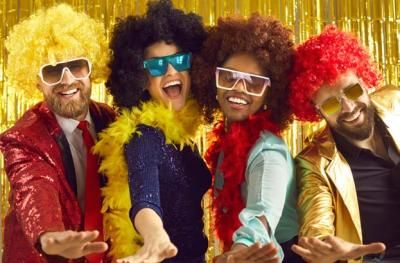 Four people at a party in wigs and novelty sunglasses