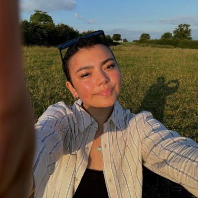 Daisy, a young person supported by Teenage Cancer Trust, smiles while taking a selfie