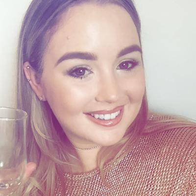 A girl smiling at the camera holding a champagne flute
