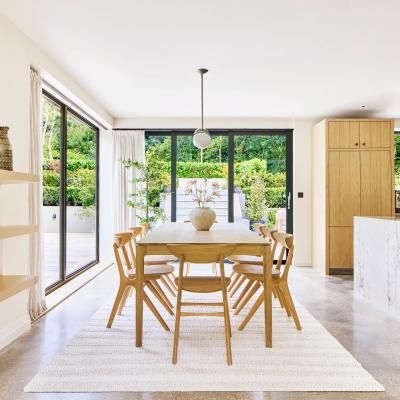A solid oak table in a dining room with garden views at the Omaze Million Pound House Draw house in the New Forest