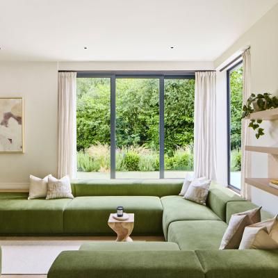 A sofa in the sunken lounge with views of the garden at the Omaze Million Pound House Draw house in the New Forest