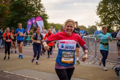 Teenage Cancer Trust runner smiles to the camera while running the Royal Parks Half Marathon