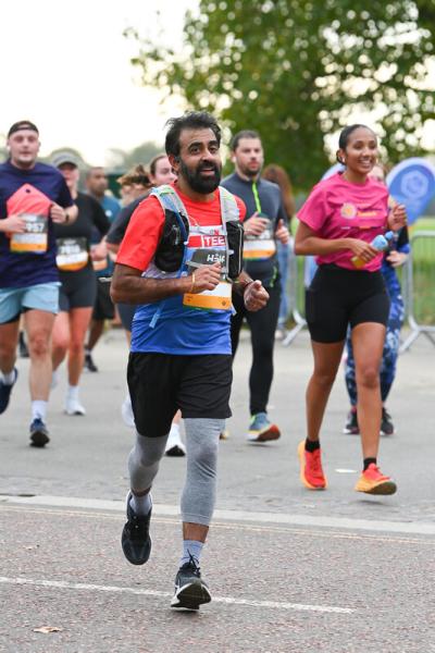 Teenage Cancer Trust runner smiles to the camera while running the Royal Parks Half Marathon