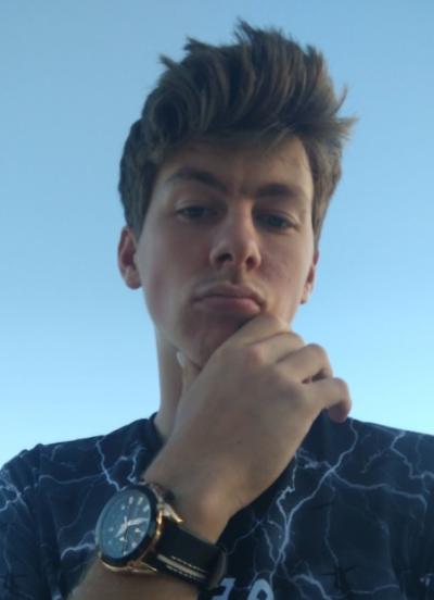 A young man with light brown hair looks directly at the camera