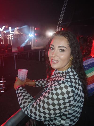 A young woman with dark hair wearing a black and white checked top