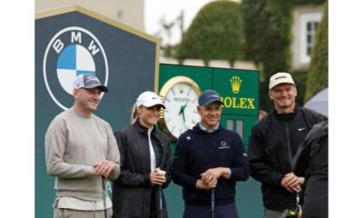 Four people in golf attire stand smiling together outdoors near BMW and Rolex signs, appearing to be at a golf event.