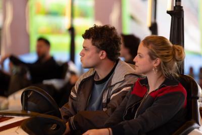A young man with brown hair and a young woman with blonde hair in a dodgem