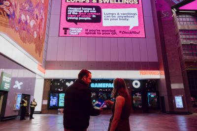 Jason with woman in front of poster outside Printworks exhibition