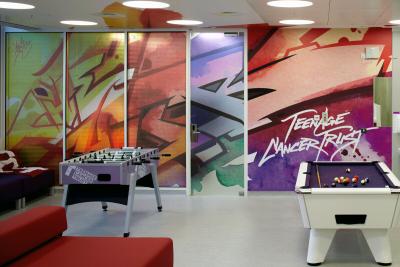 The bright and colourful Teenage Cancer Trust social area at the UCLH Cancer Centre featuring table football and pool table